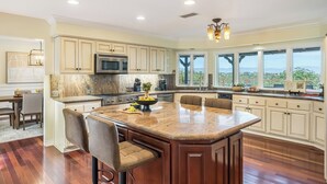 A spacious kitchen with a central island, large windows, and a view of the outdoors. - Twilight Terrace by Avantstay West Hills Retreat Hot Tub, BBQ + EV Charger, Near Malibu (West Hills)