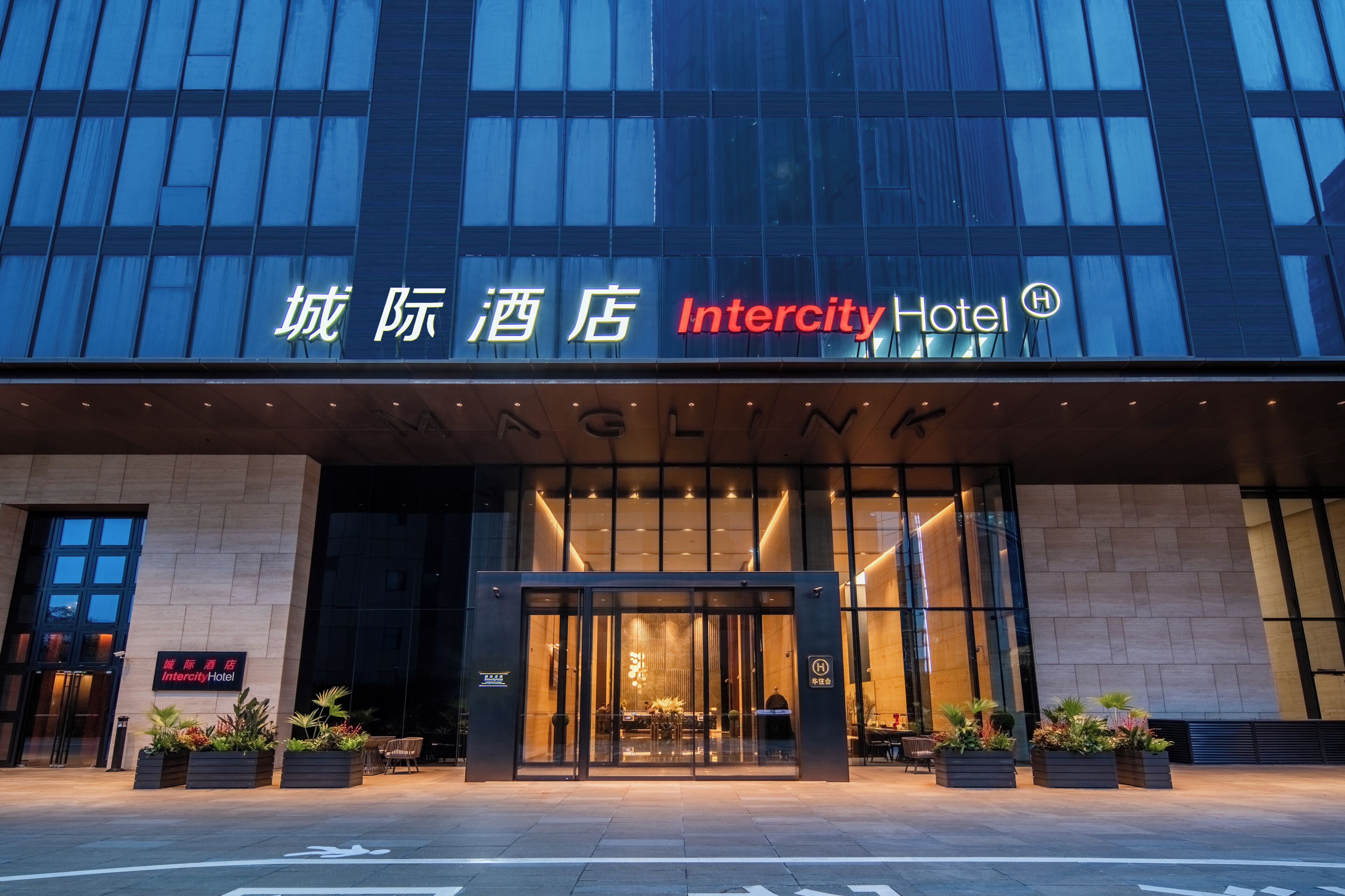 The exterior of Intercity Hotel with a modern facade, large glass entrance, and signage in multiple languages.