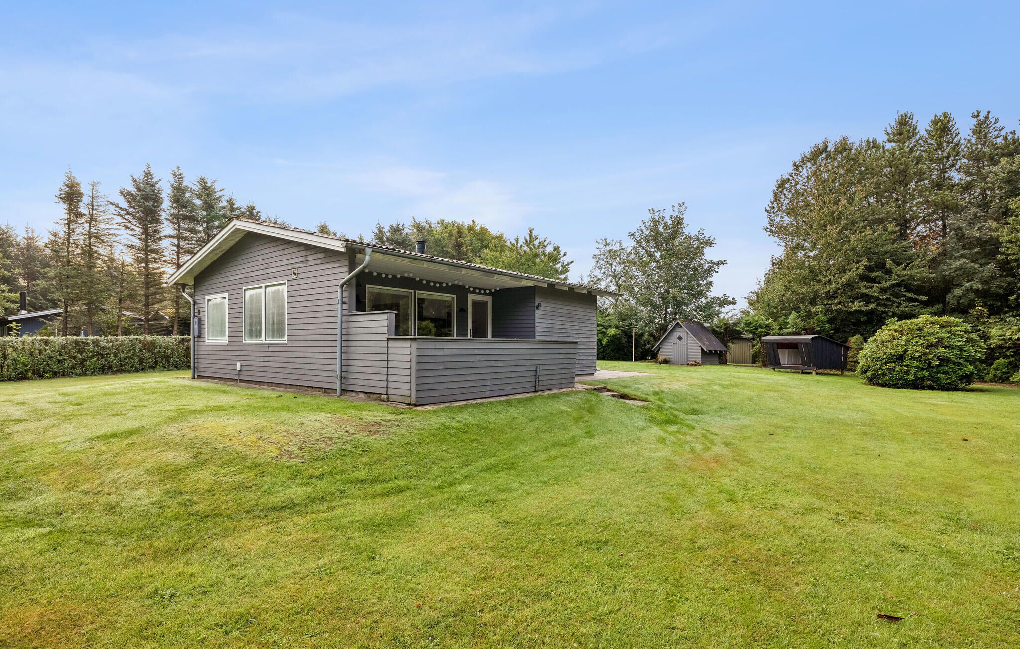 A small, single-story house with a covered porch and a well-maintained lawn.