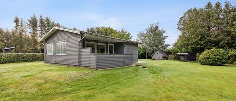 A small, single-story house with a covered porch and a well-maintained lawn.