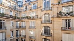 Um edifício de vários andares com varandas, grandes janelas e estilo arquitetônico clássico.
