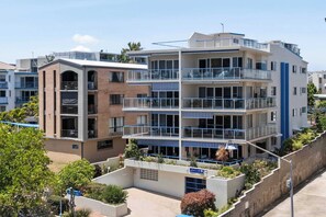 Un hôtel à plusieurs étages doté de balcons, d’une cour intérieure et d’une architecture mêlant des éléments en brique et des éléments modernes.