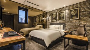 A modern hotel room with a brick wall, two beds, a desk with a computer, and a vintage telephone. - MARI Hotel  (Incheon)