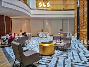 A lobby with seating areas, a central round table, and a patterned floor. - Artisan By SanLiving - 2BR - Direct Mall (Jakarta)