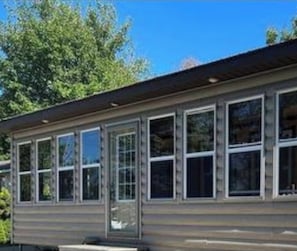 A building with a row of windows, a flat roof, and a visible door.