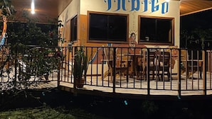 Ein Gebäude mit einem Schild, auf dem „INNIBO“ steht, und einer überdachten Außenbereich mit Tischen und Stühlen.