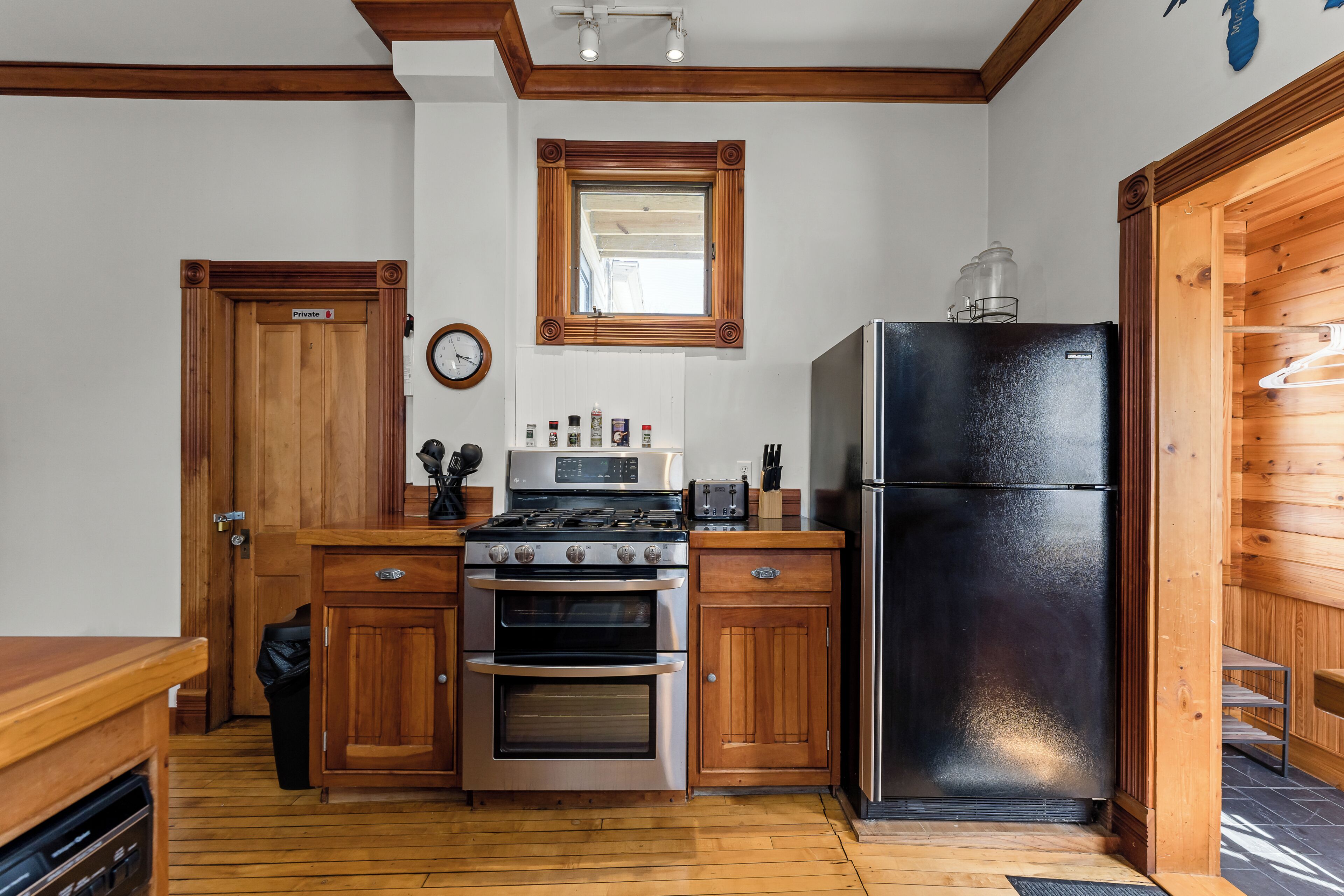 A kitchen with wooden cabinets, a stainless steel refrigerator, a microwave, and a stove.