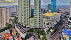 A high-rise building complex with multiple towers, surrounded by other buildings and a road. - Aria By SanLiving - 2BR - Direct Mall (Jakarta)