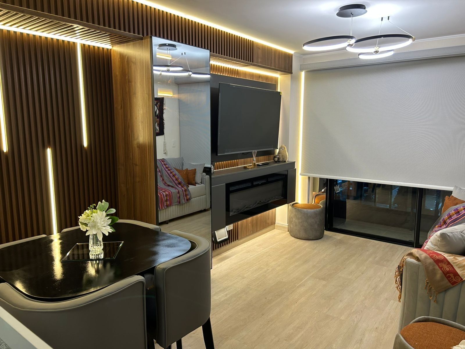 Un salon moderne avec un téléviseur à écran plat, une table à manger avec des chaises et un canapé.