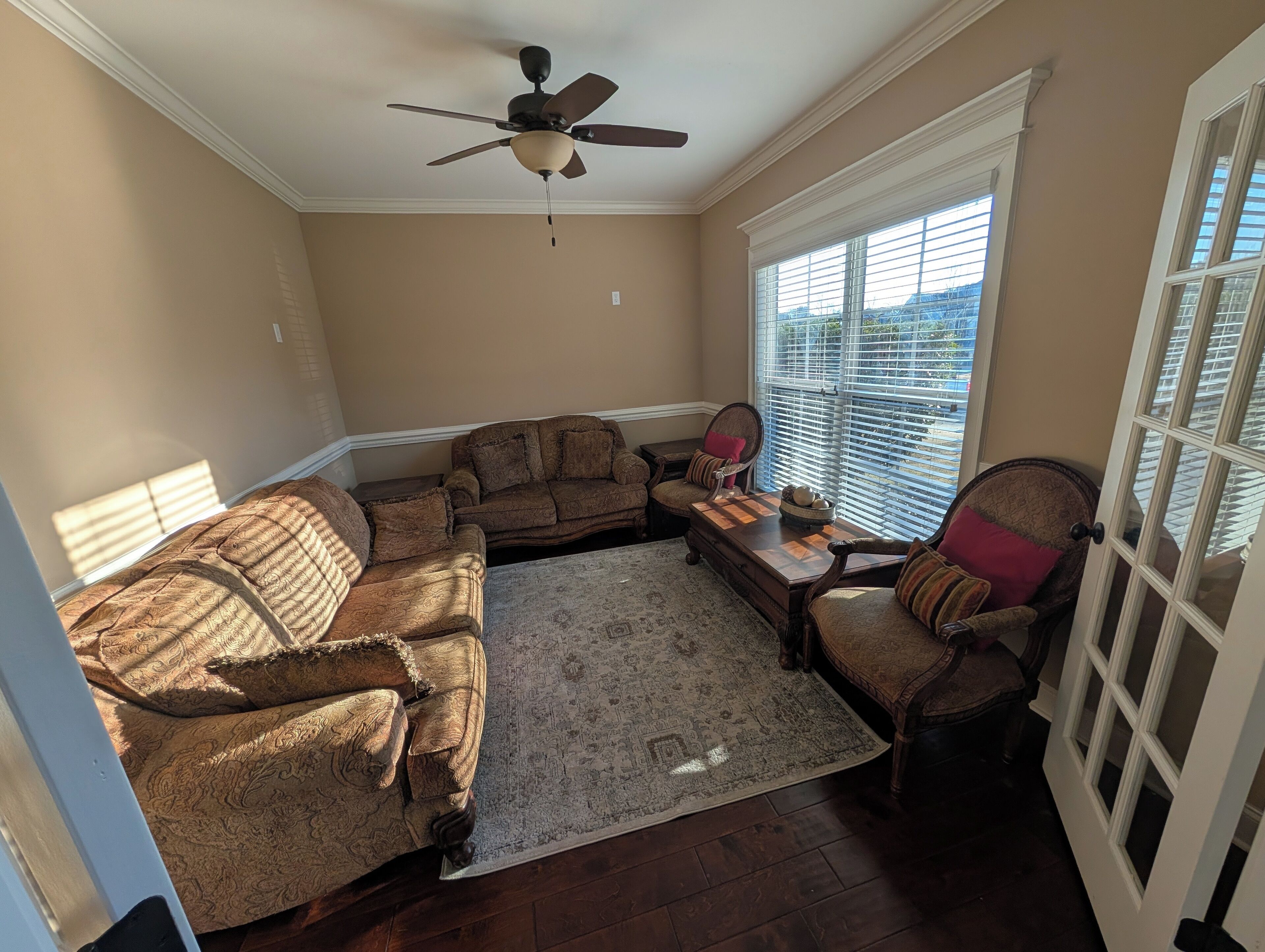 A living room with a brown patterned sofa, a matching armchair, and a wooden coffee table.
