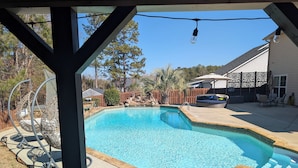 A clear swimming pool with a wooden deck and a pergola structure. - Stunning 4-Bedroom Retreat with Resort-Style Backyard in
 charming Evans. (Evans)