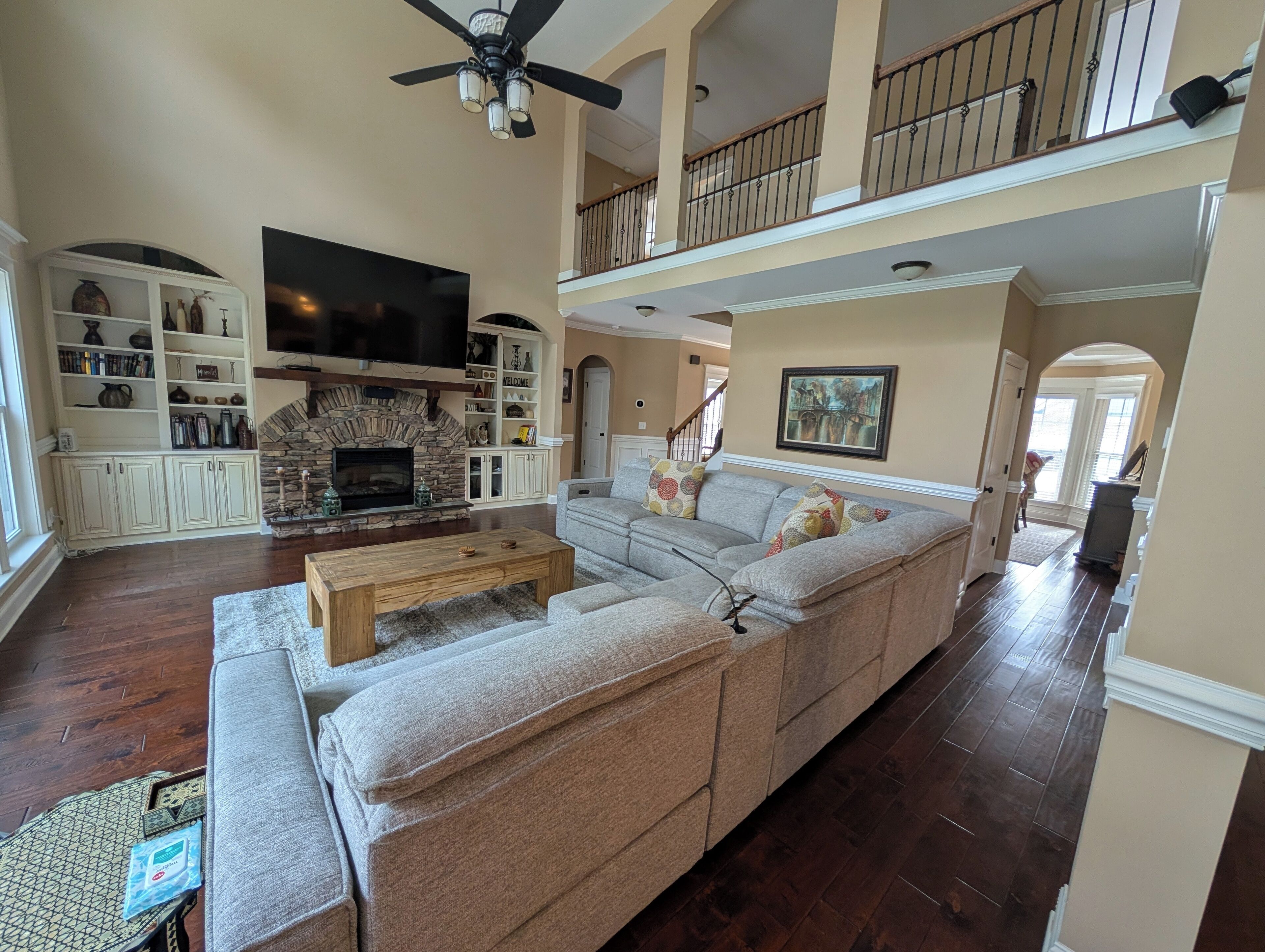 A spacious living room with a sectional sofa, a fireplace, and a television.