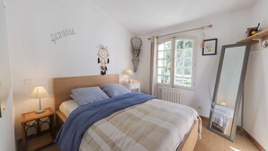 A bedroom with a bed, bedside tables, a window, and a mirror. - Beautiful 2-room apartment with Wi-Fi and mooring – View over the canals of Port Grimaud (PORT GRIMAUD)
