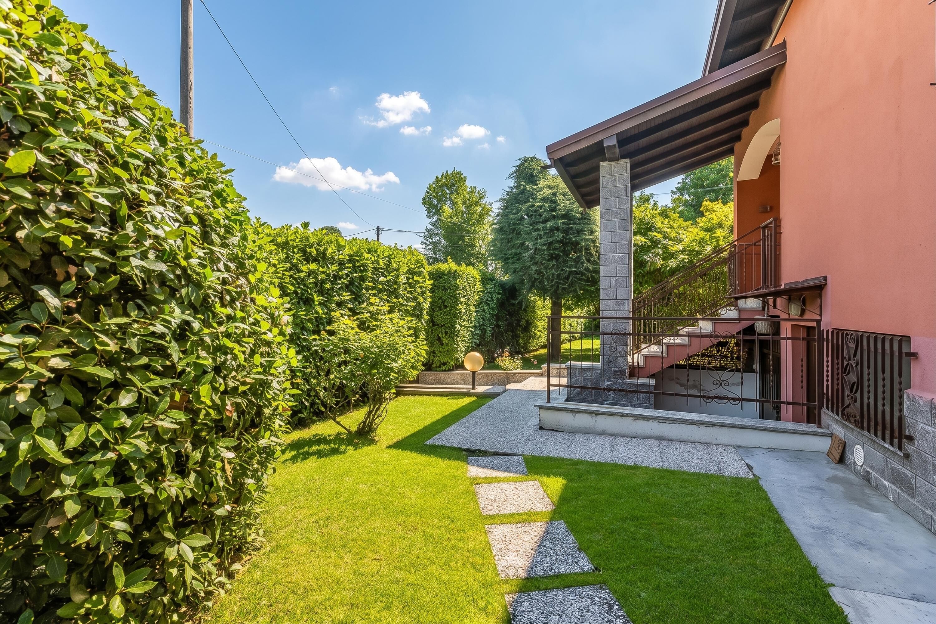 A well-maintained garden with a paved pathway leading to a building entrance.