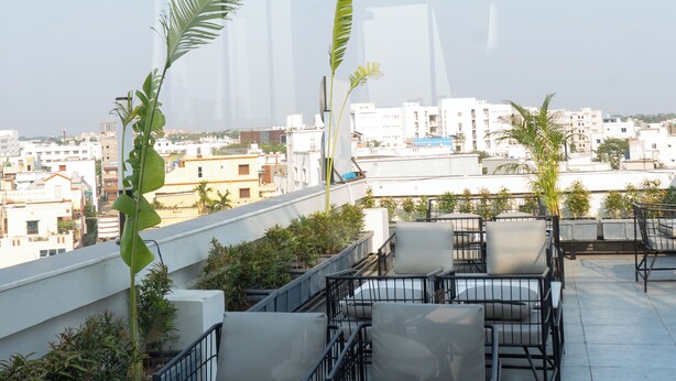 Une terrasse sur le toit, avec des sièges en plein air et une vue sur la ville.