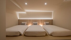 A hotel room with two single beds, a headboard with integrated lighting, and a ceiling light fixture. - Maison de Denbast (Busan)