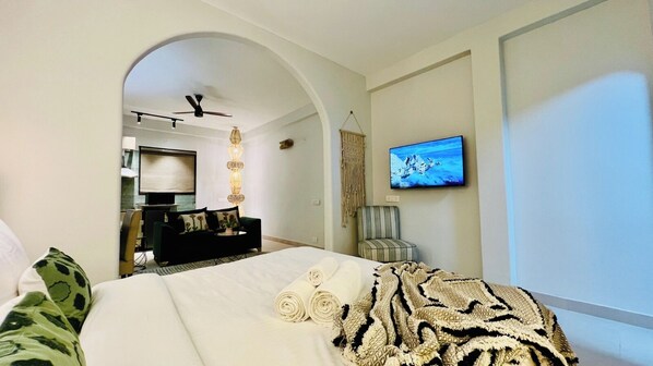 Ein Hotelzimmer mit Bett, Fernseher, Schreibtisch und Stuhl.