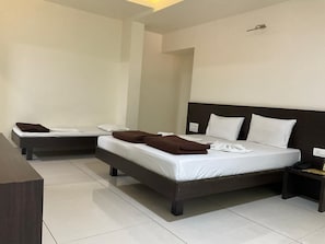 Una camera d'albergo con due letti, una scrivania e un comodino con il telefono.
