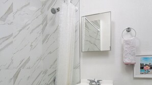 A bathroom with a bathtub, a sink, a toilet, and a shower.