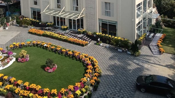 A multi-story hotel with a symmetrical facade, large windows, and a central entrance with a glass canopy. - HOTEL ABHIJIT (Uluberiya)