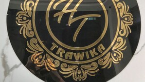 A circular sign with the text 'HOTEL TRAWIKA' and a crown symbol. - Hotel Trawika (Ahmedabad)