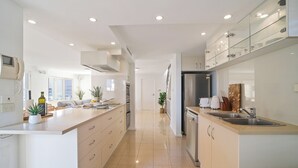 A modern kitchen with a central island, built-in appliances, and ample storage.