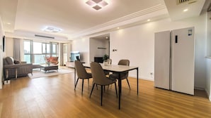 Una sala de estar moderna con comedor, un sofá, una mesa de centro y un televisor.