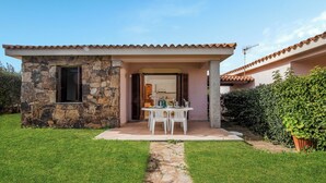 A stone house with a covered patio, a stone pathway, and a well-maintained lawn. - Le Case Della Cinta Hosue (San Teodoro)