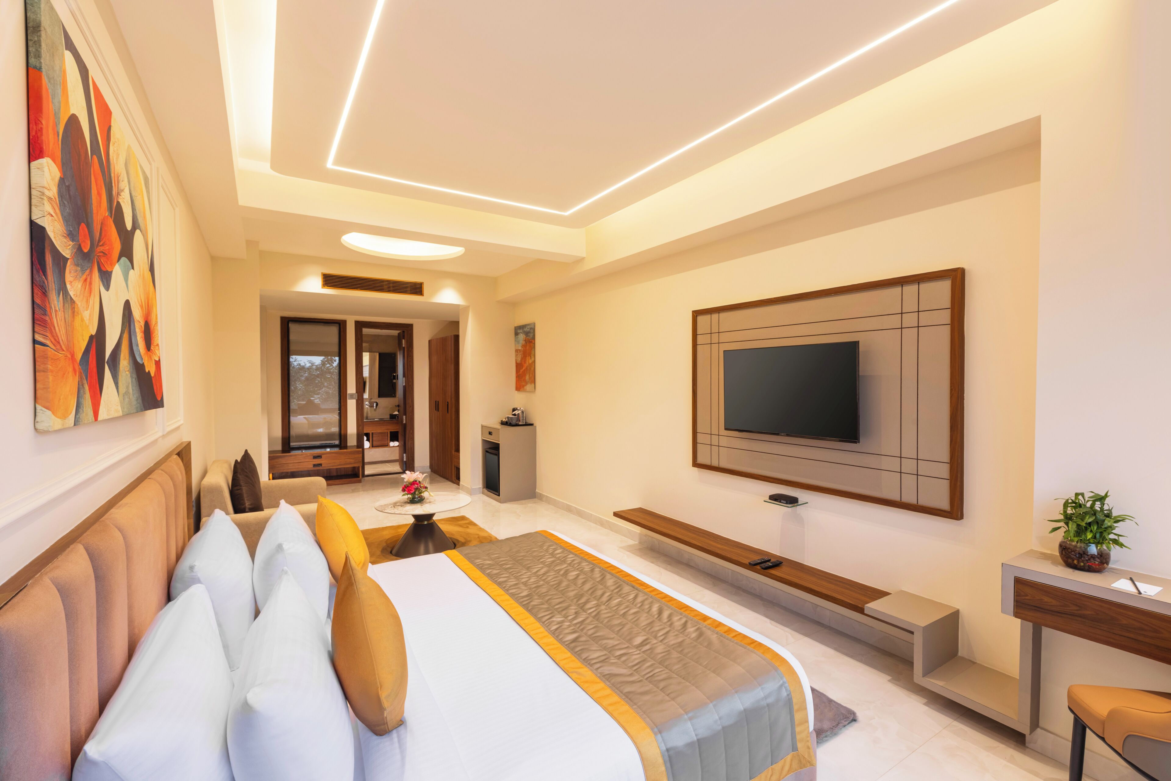 Una habitación de hotel moderna con cama, televisor, escritorio y zona de estar.