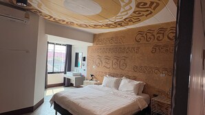 Un dormitorio moderno con una cama grande, una lámpara de techo y una pared con motivos decorativos.