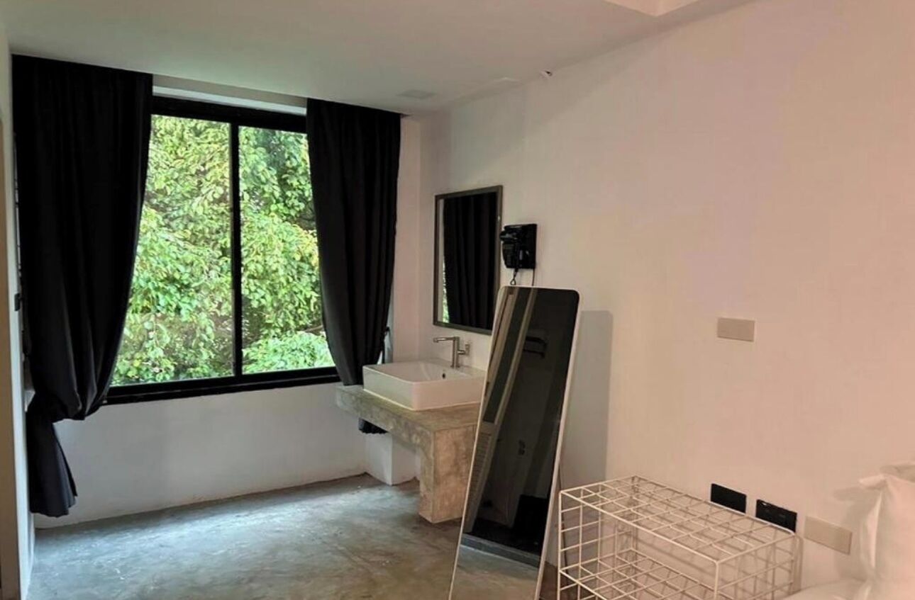 Une salle de bain moderne avec une grande fenêtre, un lavabo blanc et un miroir.