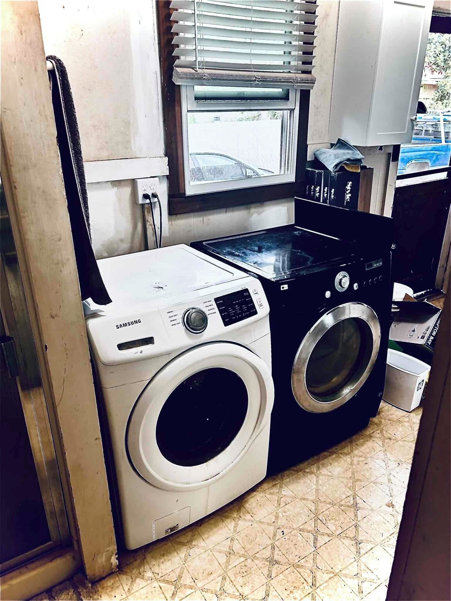 A compact laundry room with a white Samsung washing machine and a black dryer.
