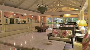 A spacious lobby with a marble floor, a central fountain, and seating areas with floral cushions. - Iberostar Waves Punta Cana (Punta Cana)