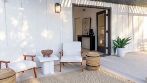 An outdoor seating area with two white chairs, a small table, and a woven basket. - Playful Luxury - Pool, Games & Near Old Town (Scottsdale)