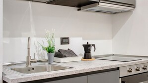 Une cuisine moderne équipée d’appareils électroménagers en acier inoxydable, d’un évier à deux bacs et d’une machine à café.