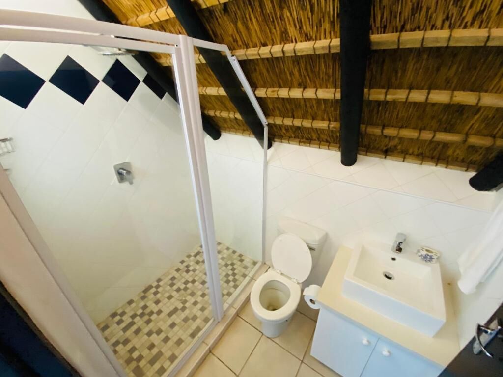 Ein Badezimmer mit Dusche, Toilette und Waschbecken.