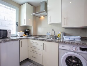 A compact kitchen with a microwave, toaster, sink, and washing machine. - Sunstay Salitre Flat I Malaga (Málaga)
