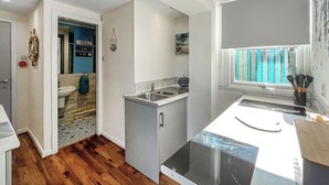 Una cocina moderna con lavavajillas integrado, un ventanal con vistas y una pequeña isla con fregadero.