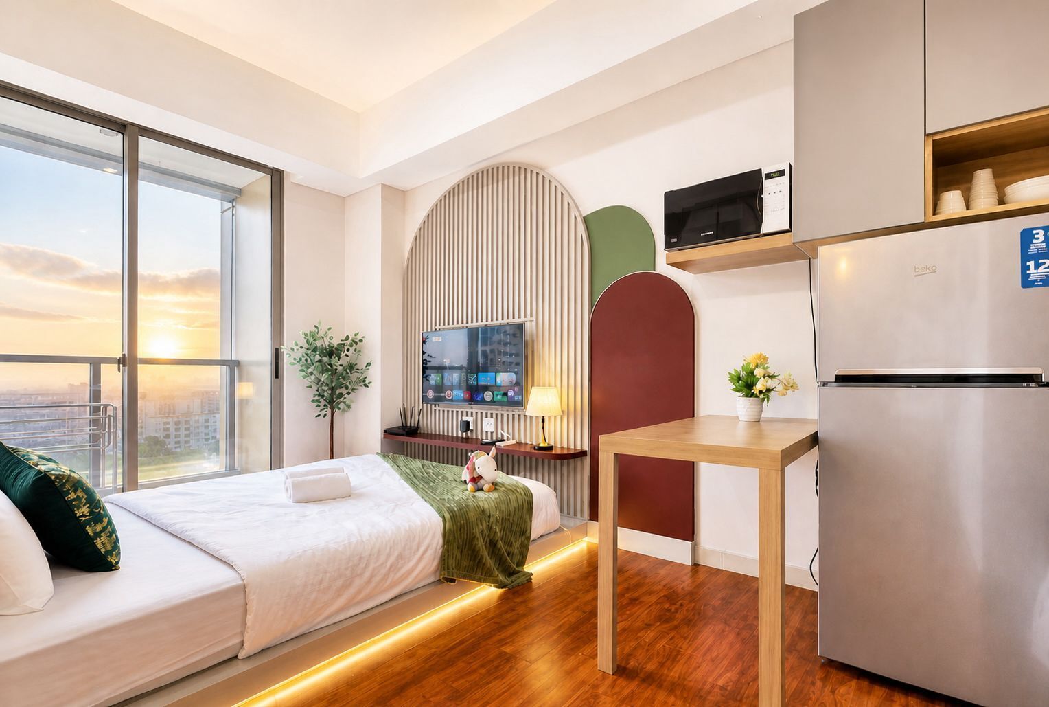 A modern hotel room with a bed, a small table, a microwave, a refrigerator, a TV, and a view of the city.