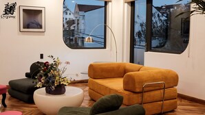 Un salon moderne avec un canapé, une table basse et une plante en pot.
