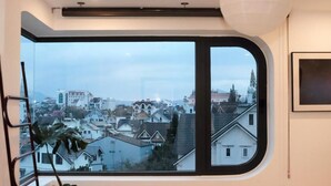 Une pièce dotée d’une grande fenêtre donnant sur un quartier résidentiel.