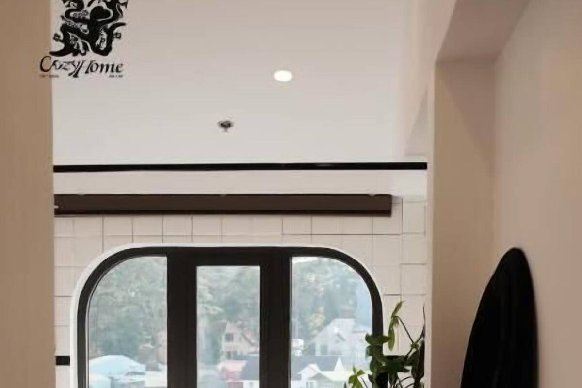 Un bagno moderno con una grande finestra, una vasca da bagno e una pianta.
