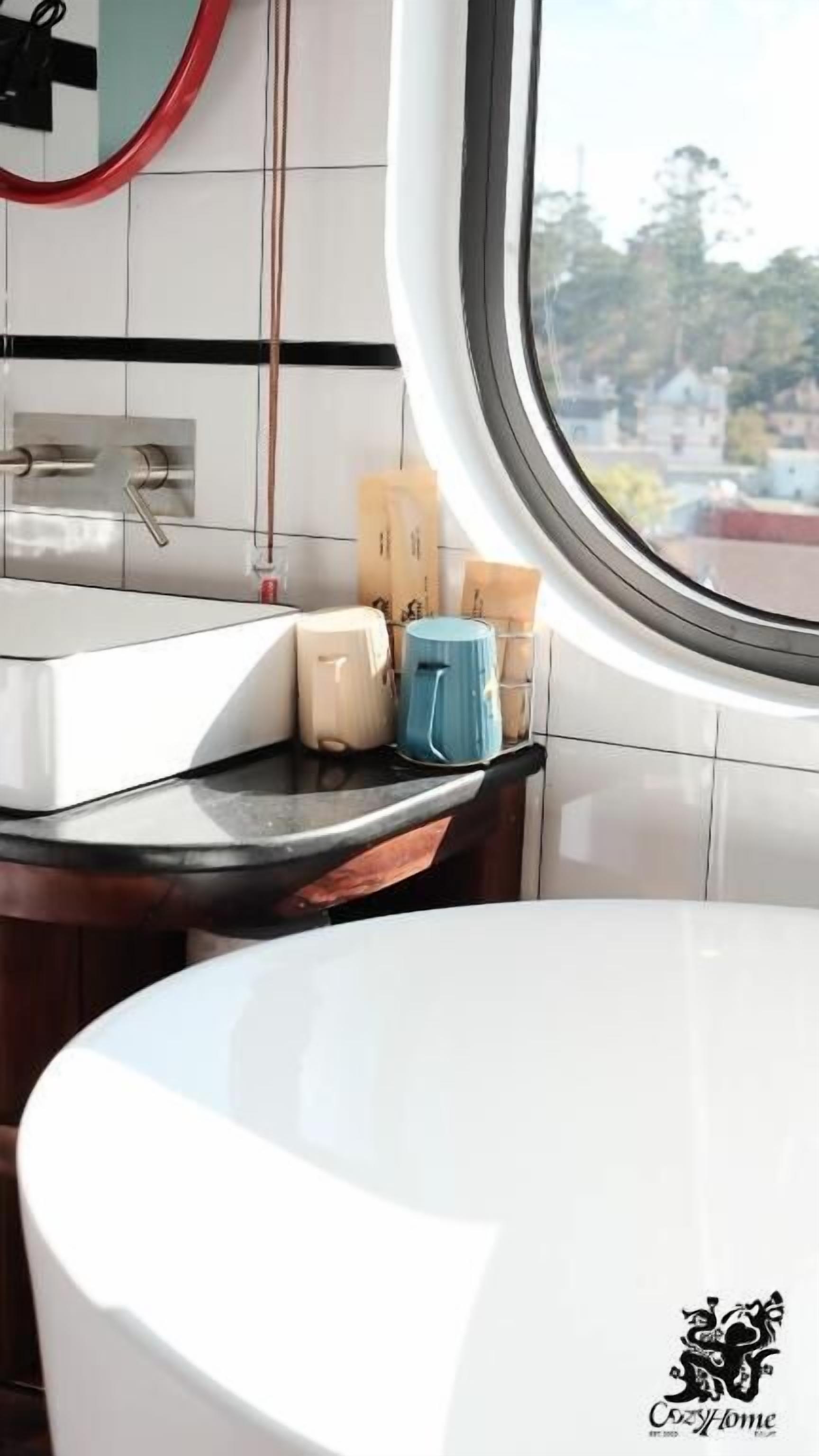 A kitchen with a white sink, a window, and a view of the outside.