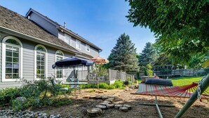 Ein Haus mit Terrasse, Hängematte und Garten mit Holzweg.