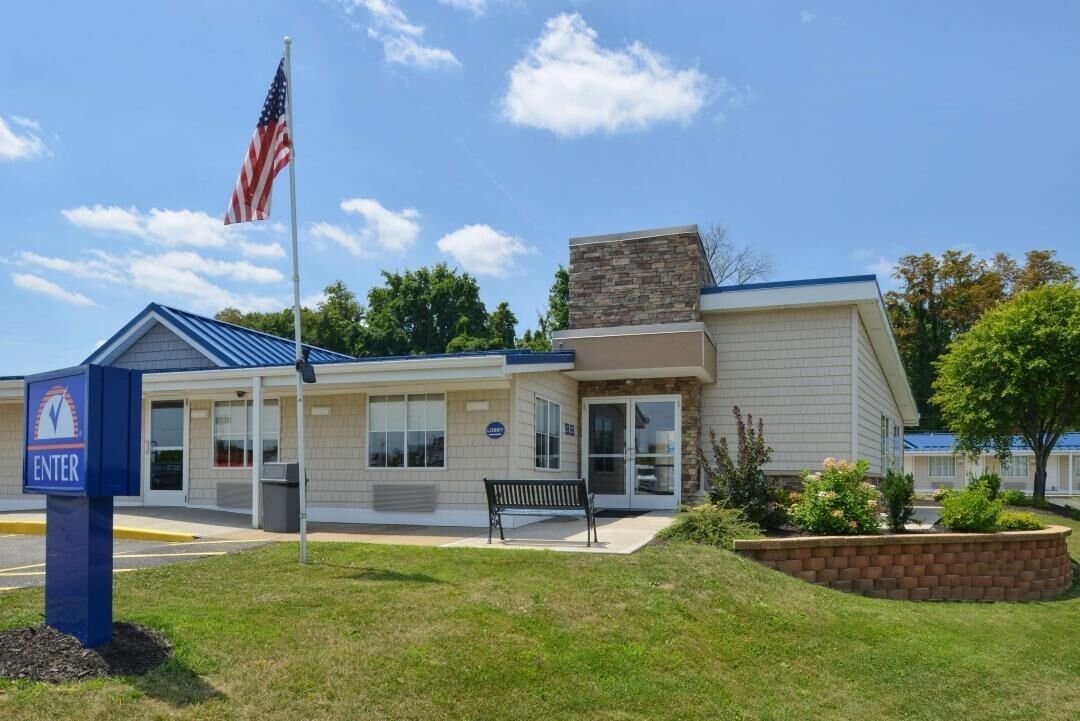 Step into a welcoming entrance surrounded by sunny, landscaped grounds.