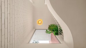 Un intérieur moderne avec un motif géométrique sur le mur, une lucarne et un luminaire suspendu.
