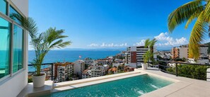 A residential building with a pool overlooking a coastal cityscape. - 4BR Full Duplex + Panoramic Pool Ocean, Bay & City Views (Puerto Vallarta)