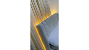 A modern chair with a white cushion and a headrest, positioned against a wall with vertical blinds. - Cozy 1-bedroom house with 247 power, FREE Wifi, Netflix, AC (Lekki)