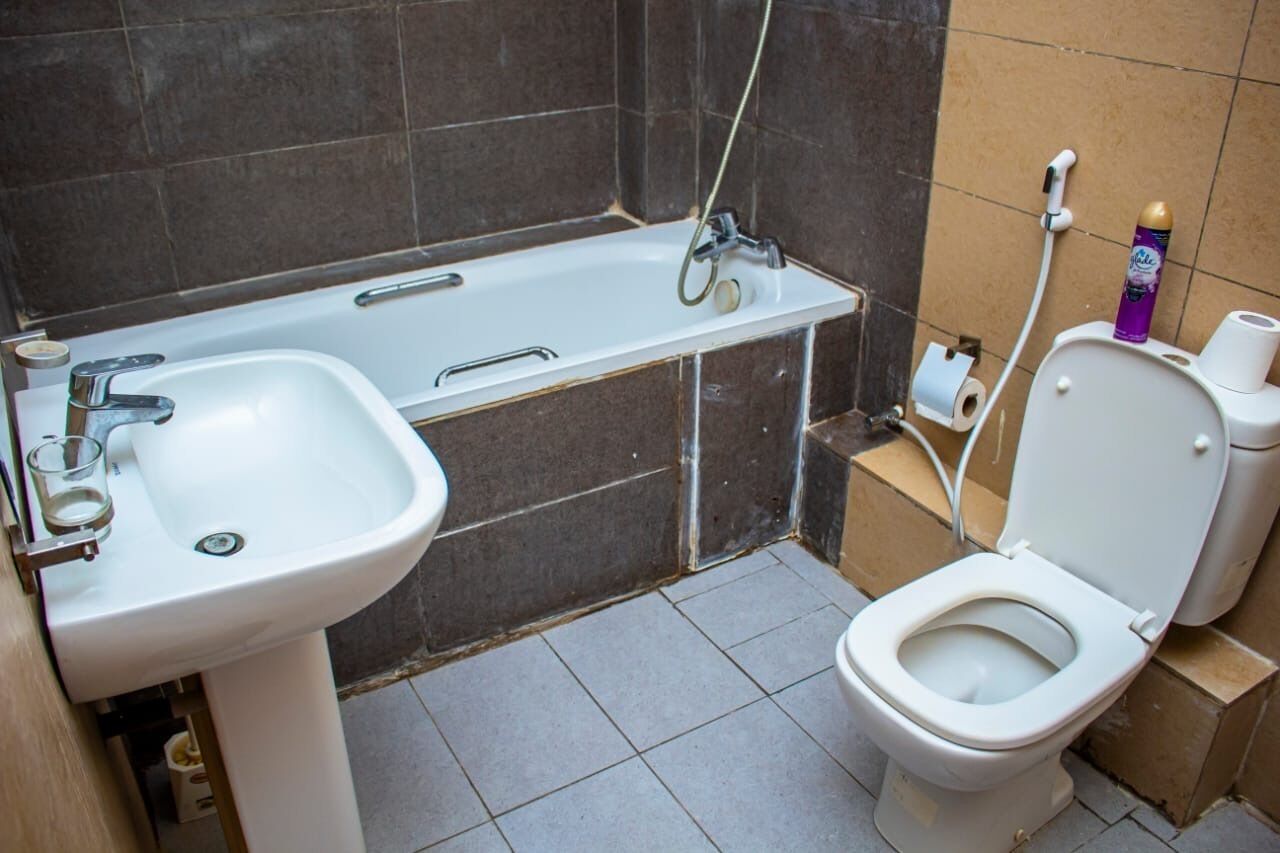 A bathroom with a white sink, a bathtub, and a toilet.