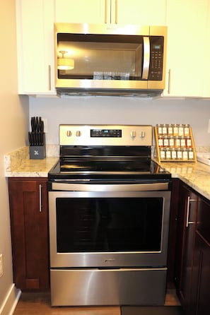 A kitchen with stainless steel appliances, including a microwave, oven, and stove.